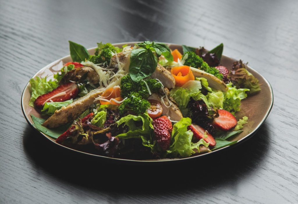 a plate of salad on a wooden table